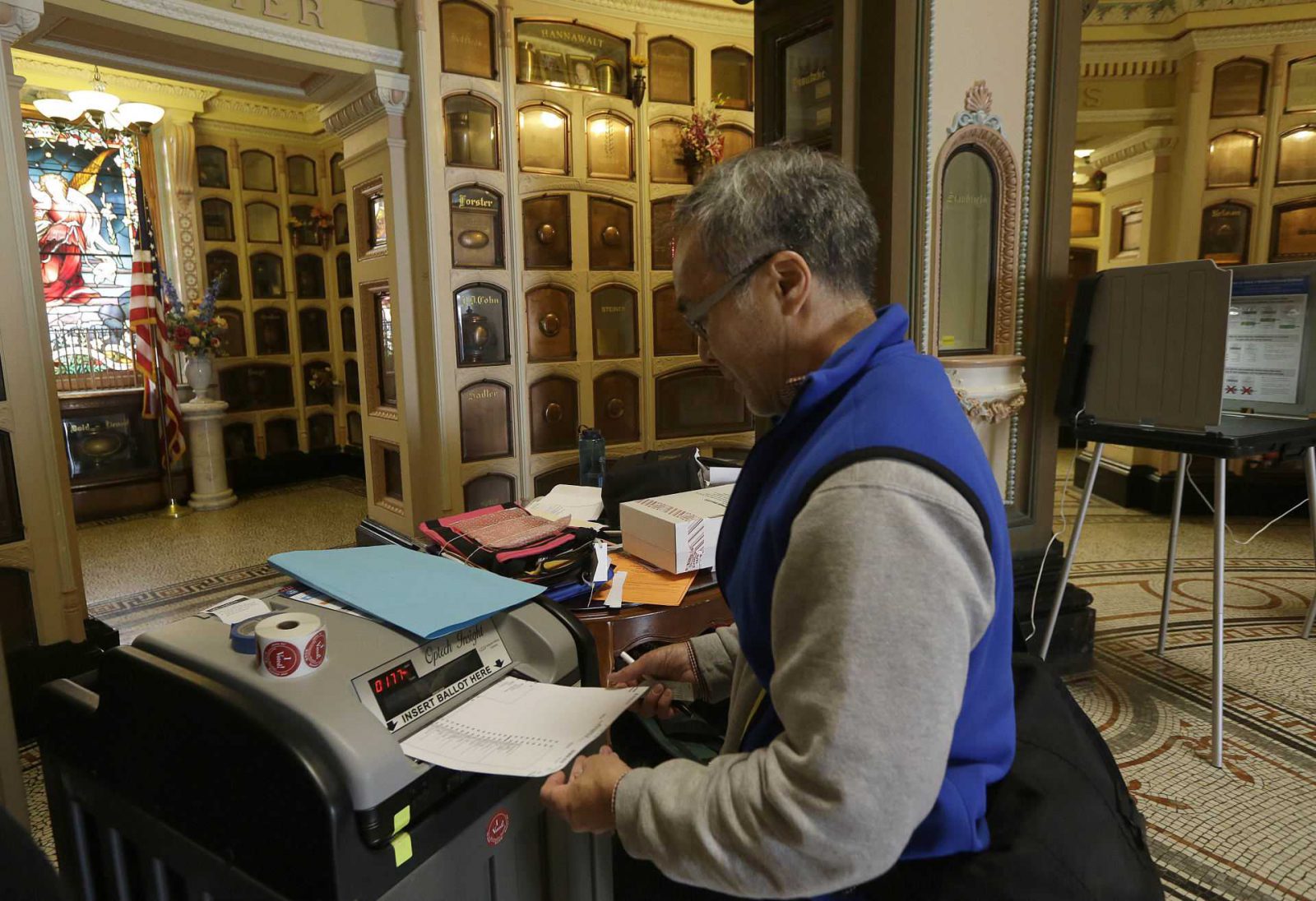 Jeff Young enters a ballot into a voting machine at the Neptune Society Columbarium, one of the last remaining cemeteries in San Francisco, Tuesday, June 7, 2016. Voter turnout is expected to be higher then normal in the nation's most populous state for Tuesday's presidential primary. (AP Photo/Jeff Chiu)